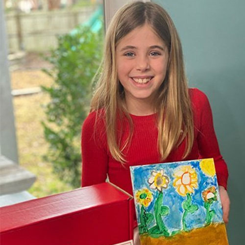Girl holding artwork completed from Family Art Box
