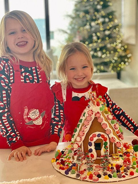 Two Girls around their Gingerbread House